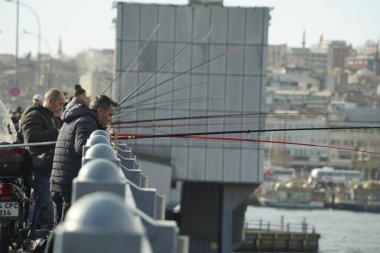 İSTANBUL, TURKEY - 5 HAZİRAN 2024 Galata Köprüsü 'nde balık tutan insanlar. Elinde olta olan bir sürü insan..