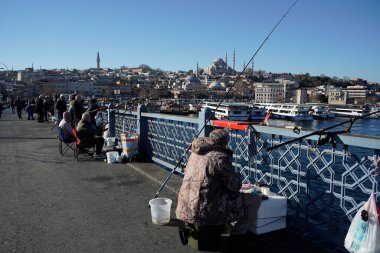 İSTANBUL, TURKEY - 5 HAZİRAN 2024 Galata Köprüsü 'nde balık tutan insanlar. Elinde olta olan bir sürü insan..