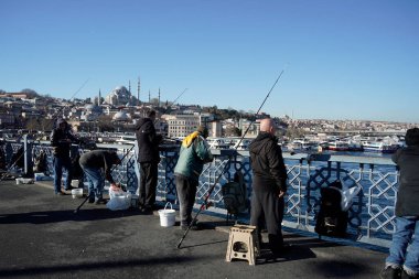 İSTANBUL, TURKEY - 5 HAZİRAN 2024 Galata Köprüsü 'nde balık tutan insanlar. Elinde olta olan bir sürü insan..