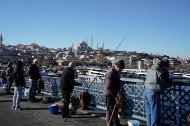 İSTANBUL, TURKEY - 5 HAZİRAN 2024 Galata Köprüsü 'nde balık tutan insanlar. Elinde olta olan bir sürü insan..