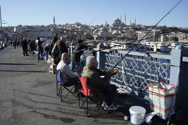 İSTANBUL, TURKEY - 5 HAZİRAN 2024 Galata Köprüsü 'nde balık tutan insanlar. Elinde olta olan bir sürü insan..