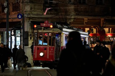 İSTANBUL, TURKEY - 5 HAZİRAN 2022: İstanbul 'un en ünlü caddelerinden biri olan İstiklal Caddesi, Taksim kamarasından geçen tarihi kırmızı tramvay. gece görünümü
