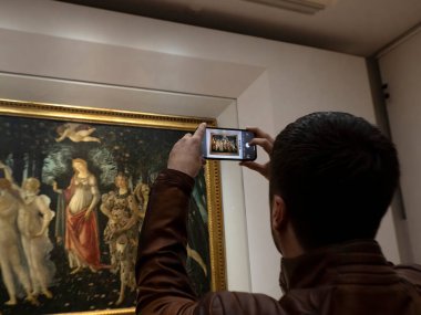 FLORENCE, ITALY - 24 Mart 2024 - Uffizi Galerisi Sandro Botticelli 'nin akıllı telefon yayıyla fotoğraf çeken turistlerle dolu dünyanın en önemli müzelerinden biri