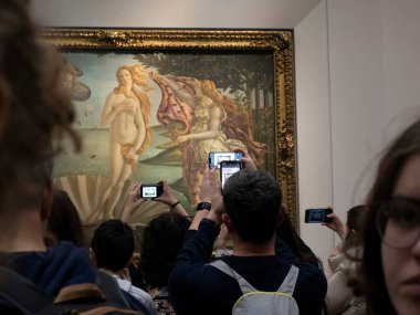 FLORENCE, İTALYA - 24 Mart 2024 - Uffizi Galerisi Sandro Botticelli 'nin Venüs' ün doğumu sırasında akıllı bir sesle fotoğraf çeken turistlerle dolu dünyanın en önemli müzelerinden biri