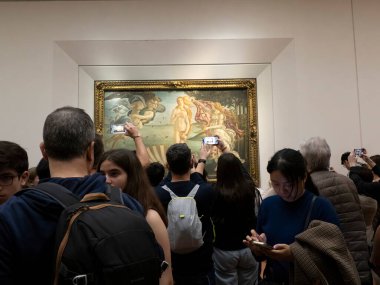 FLORENCE, İTALYA - 24 Mart 2024 - Uffizi Galerisi Sandro Botticelli 'nin Venüs' ün doğumu sırasında akıllı bir sesle fotoğraf çeken turistlerle dolu dünyanın en önemli müzelerinden biri