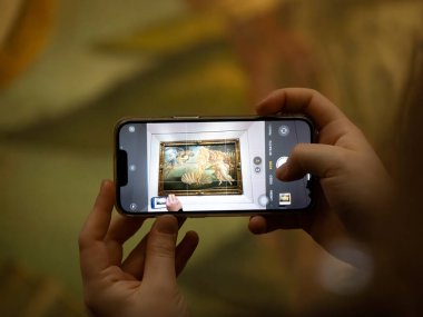 FLORENCE, İTALYA - 24 Mart 2024 - Uffizi Galerisi Sandro Botticelli 'nin Venüs' ün doğumu sırasında akıllı bir sesle fotoğraf çeken turistlerle dolu dünyanın en önemli müzelerinden biri