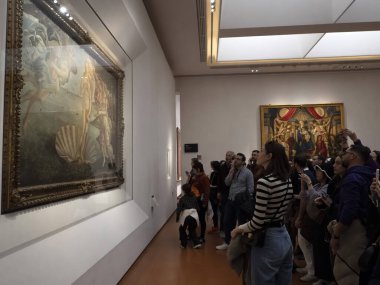 FLORENCE, İTALYA - 24 Mart 2024 - Uffizi Galerisi Sandro Botticelli 'nin Venüs' ün doğumu sırasında akıllı bir sesle fotoğraf çeken turistlerle dolu dünyanın en önemli müzelerinden biri