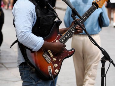 Gitar çalan siyah adamın elleri yakın mesafede.