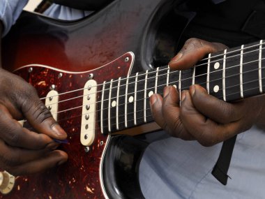 Gitar çalan siyah adamın elleri yakın mesafede.