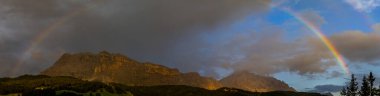 Stunning Double rainbow on the monte croce cross mountain in dolomites badia valley panorama landscape clipart