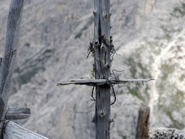 A detail of wooden cross of soldier died in first world war mountain Cemetery in foxhole in Dolomites, Italy clipart