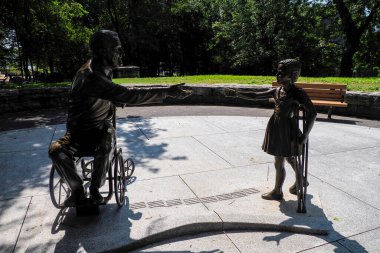 NEW YORK, USA - AUGUST 28 2024 - FDR Hope Memorial in Southpoint Park at southern end of Roosevelt Island in New York City. Focuses on disability, FDR greets a young girl who wears braces on her legs clipart