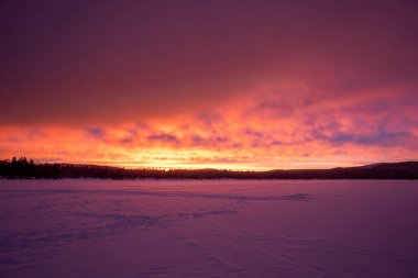 Laponya 'da öğle vakti Kızıl bir gün doğumu Inari Nellin Gölü