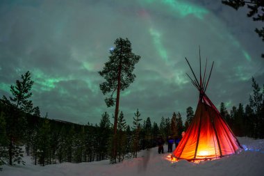 Sami, Lapland Inari Nellin Lake Ormanı 'nda Kuzey Işıkları ile çadır kurdu.