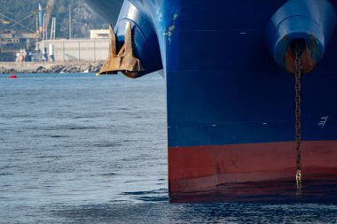 Limanın dışında demirli büyük bir gemi var.