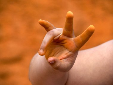 Kolorado Ocher Kanyonu 'na kırmızı toprak döken genç bir kızın elleri Provence Fransa' daki kalabalık vadide.