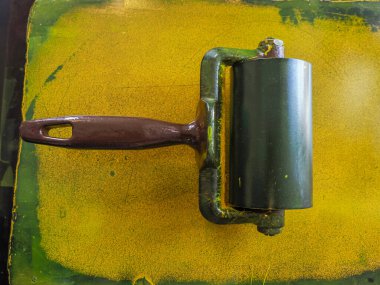 Sarı renkli bir çubuk, eski bir baskı makinesi.