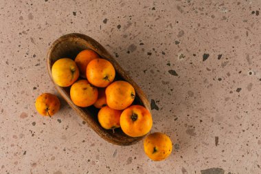 Meksika 'da kış mevsimi meyveleri, pembe taş ocağının arka planında ahşap bir kasede Tejocotes.