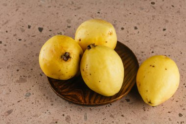 Meksika 'da kış mevsimi meyveleri, pembe bir taş ocağında ahşap bir tabakta dev guavalar..