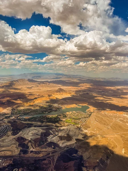 Aerial photography of the Nevada desert, United States, you can see the mountains, the desert plain, a lake with a river, the clouds and the sky.