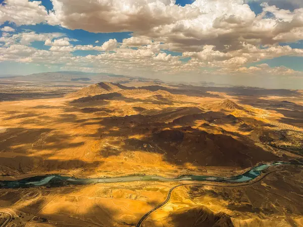 Aerial photography of the Nevada desert, United States, you can see the mountains, the desert plain, a lake with a river, the clouds and the sky.