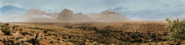 Nevada, ABD 'deki Redrock Ulusal Parkı' nın birkaç fotoğrafından panoramik manzara fotoğrafı çekildi. Çöl vadisini ve devasa kızıl kaya dağlarını görebilirsiniz..