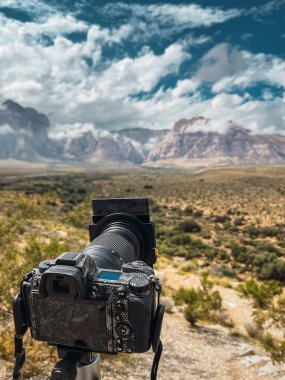 Fotoğraf makinesi Amerika Birleşik Devletleri 'nin Nevada eyaletindeki Redrock Ulusal Parkı' nın manzarasını çekiyor. Çöl vadisini ve devasa kızıl kaya dağlarını görebilirsiniz..