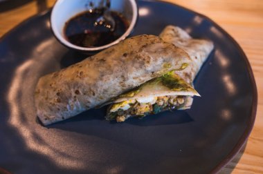 Yumurta ve sebzelerle doldurulmuş burrito, yanında da salsa macha.