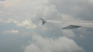 Bir uçağın penceresinden kaydedilen video geziyi gösteriyor. Bulutları, gökyüzünü, uçağın kanadını ve günbatımını görebilirsiniz..