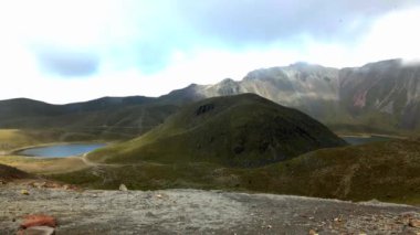 Meksika, Nevado de Toluca 'nın 4K videosu. Bulutlar Güneş ve Ay' ın gölleri üzerinde karanlık ışık üretiyor..
