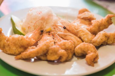 Yanında beyaz pirinç ve avokado eşliğinde karides..