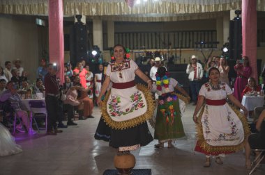 Geleneksel Meksika düğünü, Michoacan Eyaleti tarzında, Purpecha tarzında, dansçılar şallar, huipiller, şapkalar ve battaniye giysileri gibi alanlardan giyiniyorlar..