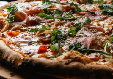 Serrano jambonlu Margherita Pizzası malzemelerini, peynirini, domatesi ve güzel otlarını gösteriyor..