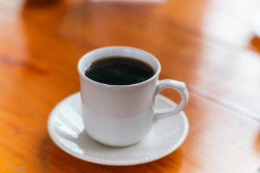 Beyaz bir fincanda servis edilen Amerikan kahvesi, son hasattan sonra taze öğütülmüş..