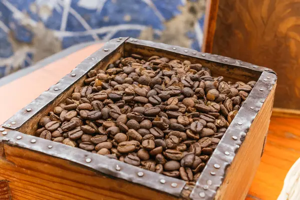 Coffee beans ready to be ground placed in a wood square.