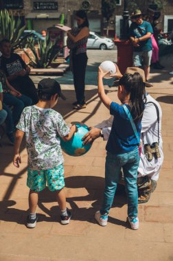 Bilim adamı ölçekli gezegenlere sahip çocuklara tutulmanın hareketini ve işlevini öğretiyor..
