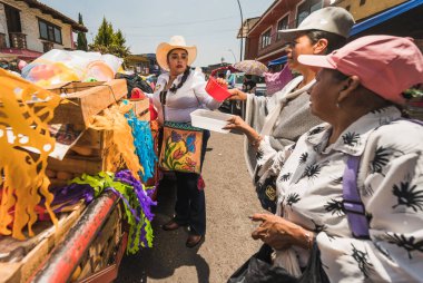 İnsanlar geleneksel San Isidro yürüyüşü festivalinde yemek ve hediye dağıtıyor. Metepec, Meksika, Meksika.