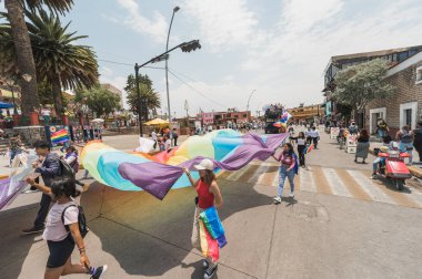 LGBT topluluğundan insanlar çok renkli bayraklar taşıyorlar, Meksika 'nın Metepec şehrindeki Onur Yürüyüşü' nde, kostümler içinde geçit yapıyorlar ve makyaj yapıyorlar..