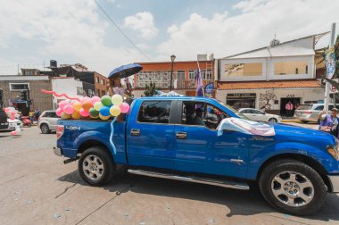 LGBT topluluğundan insanlar çok renkli bayraklar taşıyorlar, Meksika 'nın Metepec şehrindeki Onur Yürüyüşü' nde, minibüs ve kamyonlarla geçit yapıyorlar..