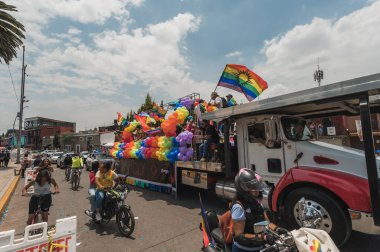 LGBT topluluğundan insanlar çok renkli bayraklar taşıyorlar, Meksika 'nın Metepec şehrindeki Onur Yürüyüşü' nde, minibüs ve kamyonlarla geçit yapıyorlar..
