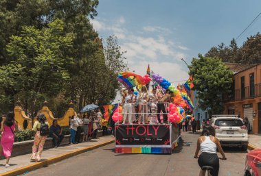 LGBT topluluğundan insanlar çok renkli bayraklar taşıyorlar, Meksika 'nın Metepec şehrindeki Onur Yürüyüşü' nde, minibüs ve kamyonlarla geçit yapıyorlar..