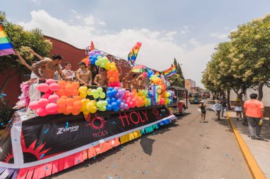 LGBT topluluğundan insanlar çok renkli bayraklar taşıyorlar, Meksika 'nın Metepec şehrindeki Onur Yürüyüşü' nde, minibüs ve kamyonlarla geçit yapıyorlar..