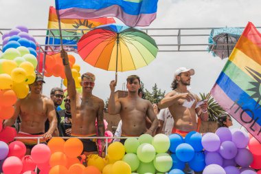 LGBT topluluğundan insanlar çok renkli bayraklar taşıyorlar, Meksika 'nın Metepec şehrindeki Onur Yürüyüşü' nde, minibüs ve kamyonlarla geçit yapıyorlar..