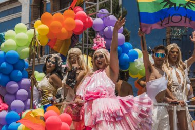 LGBT topluluğundan insanlar çok renkli bayraklar taşıyorlar, Meksika 'nın Metepec şehrindeki Onur Yürüyüşü' nde, minibüs ve kamyonlarla geçit yapıyorlar..