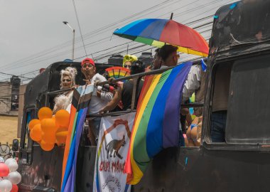 LGBT topluluğundan insanlar çok renkli bayraklar taşıyorlar, Meksika 'nın Metepec şehrindeki Onur Yürüyüşü' nde, minibüs ve kamyonlarla geçit yapıyorlar..