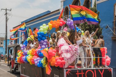LGBT topluluğundan insanlar çok renkli bayraklar taşıyorlar, Meksika 'nın Metepec şehrindeki Onur Yürüyüşü' nde, minibüs ve kamyonlarla geçit yapıyorlar..