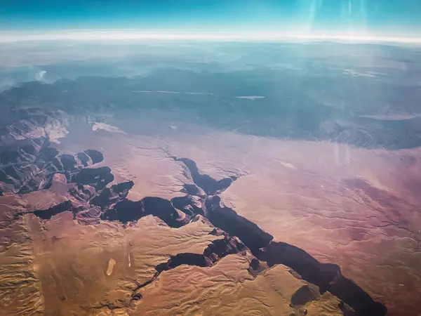 stock image Aerial photograph from an airplane. Mountains, clouds, and a canyon can be seen.