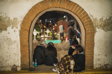 Cempasuchil çiçeklerle, mumlarla süslenmiş mezarları izleyen Meksikalı insanlar kahve içerken, puro içerken, gülerken ve bu samimi anın tadını çıkarırken....