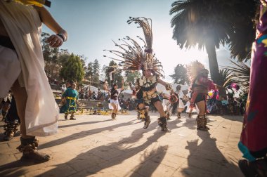İspanyol öncesi kostümlü dansçılar, Yeni Ateş Töreni 'nde bahar ayinlerini karşılamak için ritüel danslarını yapıyorlar. Güneş arkalarında, Meksika' nın Metepec kentindeki Calvary Merdivenleri 'nde..