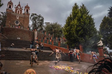 İspanyol öncesi kostümlü dansçılar, bahar ayini sırasında Meksika 'nın Metepec kentindeki Calvary Merdivenleri' ndeki tören için meşalelerini yakarak ritüel danslarını yapıyorlar..